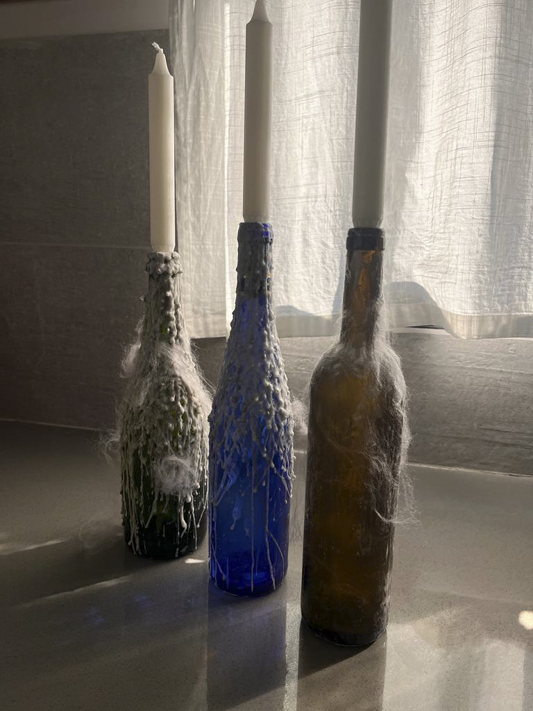 טיפטופים של נר על בקבוקי יין צבעוניים הופכים אותם לפמוטים יפיפיים. פיזרתי מעל טיפה קמח ועטפתי את הבקבוקים מעט בצמר גפן.